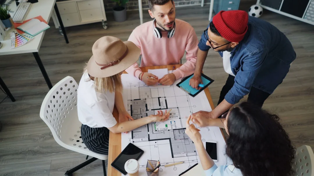 A team collaborates in an office meeting on marketing strategy, using data charts and documents.